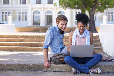 Buy stock photo Shot of two college students studying together on campus grounds