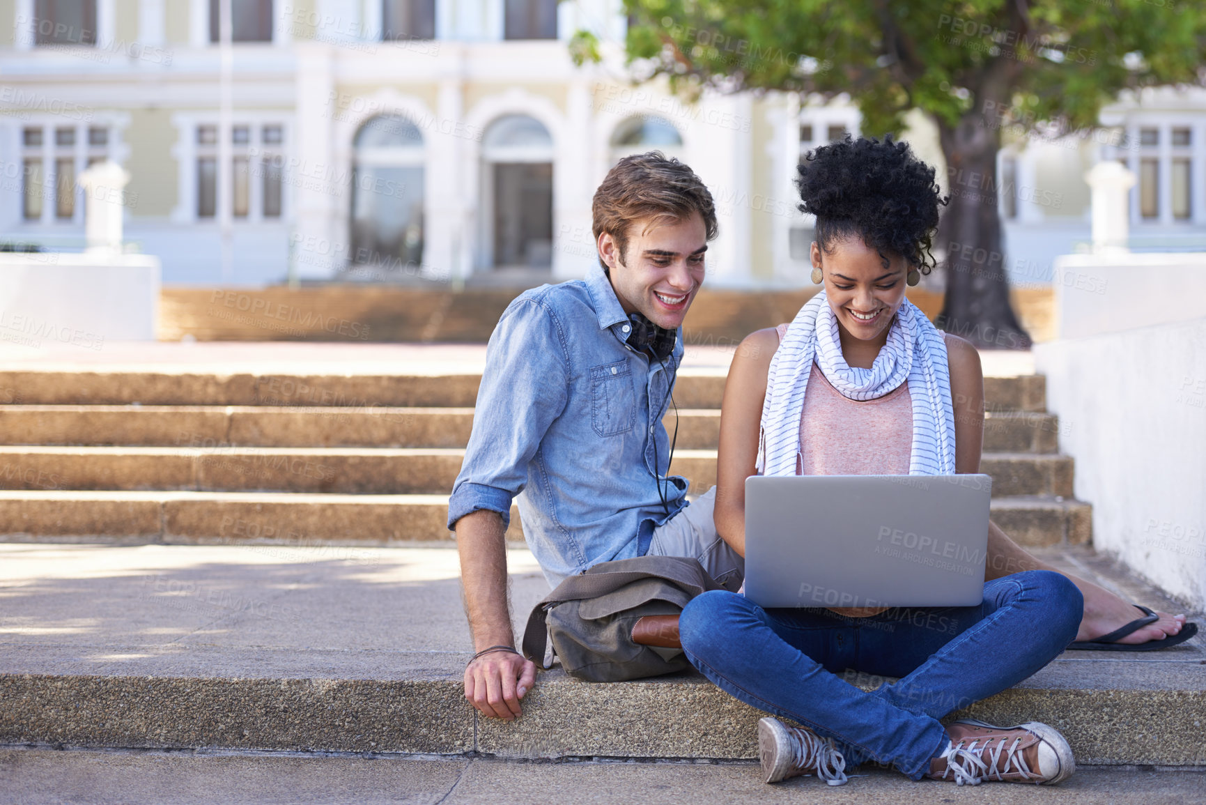 Buy stock photo Shot of two college students studying together on campus grounds