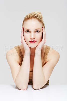 Buy stock photo Portrait, hands and skincare of woman in makeup at table, red lipstick or cosmetics in studio isolated on a white background. Face, touch or beauty model in facial treatment, wellness or healthy glow