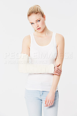 Buy stock photo Portrait, sad and woman with arm plaster in studio isolated on a white background. Injury, cast and injured girl with pain or fibromyalgia, inflammation or broken bones and depression after accident.
