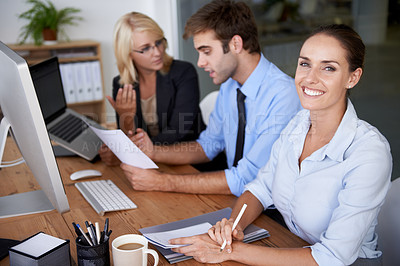 Buy stock photo Portrait of business woman at desk with team, confidence and career in market research office. Agency leader, professional people and project manager at startup with smile on face at staff workshop.