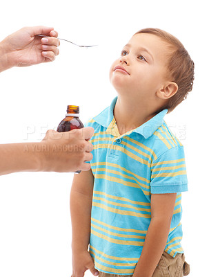 Buy stock photo Hands, medicine bottle and spoon for boy in studio, sad and thinking with tongue by white background. Kid, mother and liquid for healthcare, pharmaceutical product and helping sick child for wellness