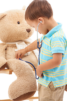 Buy stock photo Boy child, teddy bear and stethoscope in studio for playing doctor, listening and wellness by white background. Kid, healthcare game and development with plushie toys, medical check or consultation