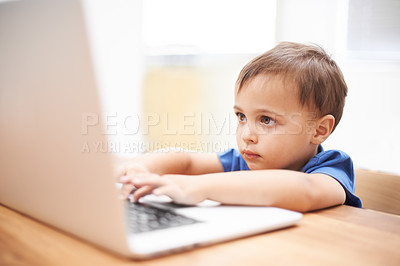 Buy stock photo Boy child, laptop and typing in home, reading or search for movie, cartoon or elearning for development. Kid, computer and click keyboard at desk in family house for education, study or online course