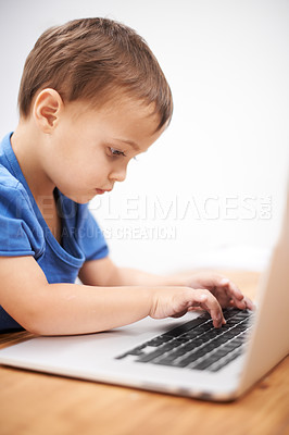 Buy stock photo Boy kid, laptop and typing in home, reading or search for movie, cartoon or elearning for development. Child, computer and click keyboard at desk in family house for education, study or online course