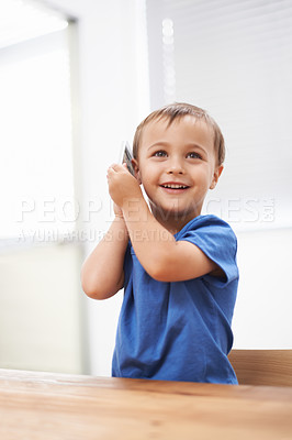 Buy stock photo Toddler, boy and phonecall in house, happiness and communication with technology. Table, cheerful and conversation for learning, cellphone and excited for child development, mobile and digital