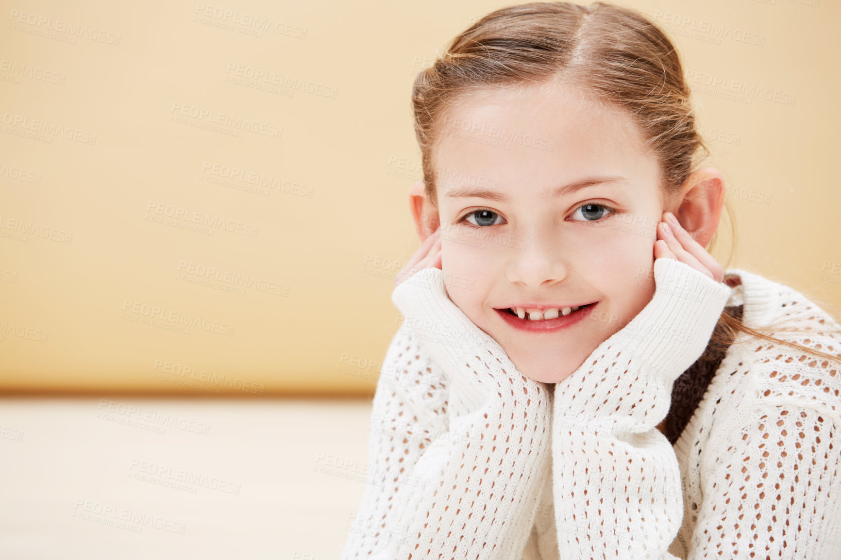 Buy stock photo Cropped portrait of a cute little girl smiling while lying on the floor