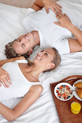 Buy stock photo Above of happy couple, morning and breakfast in bed to wake up with food or meal together to relax. Man, smile or woman in home eating healthy snack or drinking juice for diet for love in bedroom 