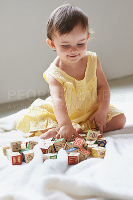 Buy stock photo Baby, girl and child, blocks as toys for learning, playing at home for education and alphabet. Growth, early childhood development and toddler with educational activity, playtime and montessori
