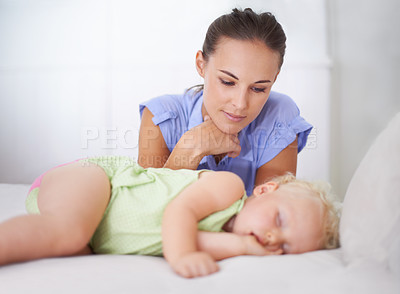 Buy stock photo Shot of a mother watching over her sleeping child