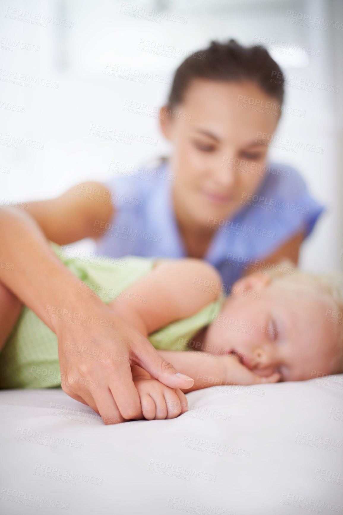 Buy stock photo Hands, sleeping and mom with baby on bed for bonding, relax and sweet cute relationship. Happy, smile and young mother watching girl child, kid or toddler taking a nap in bedroom or nursery at home.