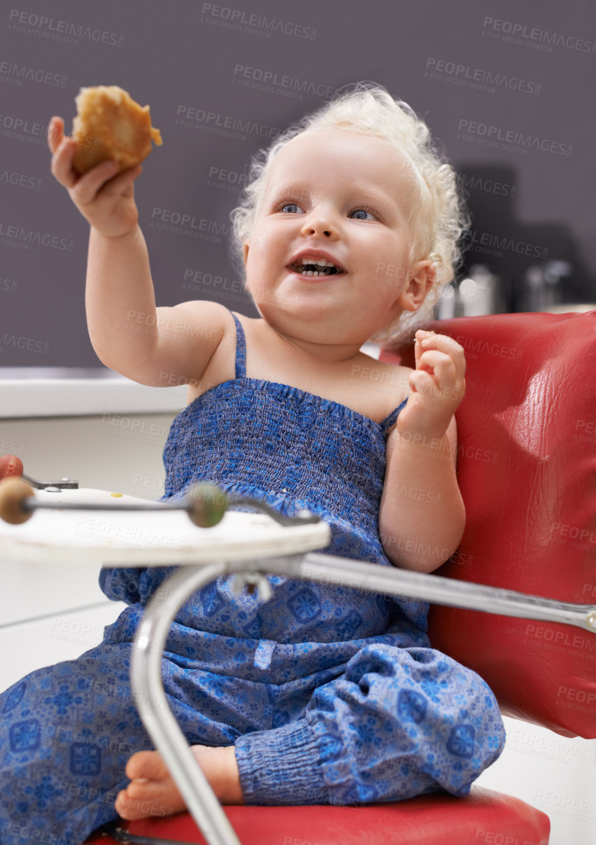 Buy stock photo Child, high chair and eating muffin, food and breakfast sweets at home in kitchen. Young kid, hungry toddler and cupcake dessert, sugar and pastry snack for happy cute girl in house in the morning