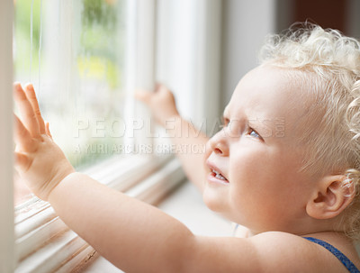 Buy stock photo Baby, window and child thinking by glass at home, curious and sad alone. Young kid, blonde toddler and dream of cute girl at house, watching and childhood expression of learning with rain weather