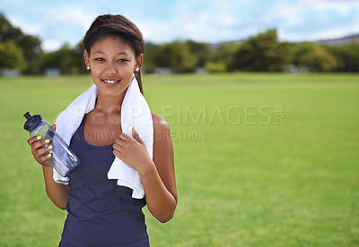 Buy stock photo Woman, portrait and water bottle in fitness on green grass for workout, exercise or outdoor training. Face of female person or athlete with towel, drink or mineral liquid for natural sustainability