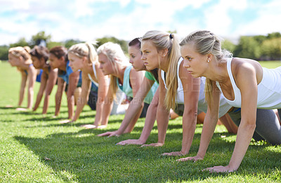 Buy stock photo Shot of women doing push ups at an outdoors excercise class