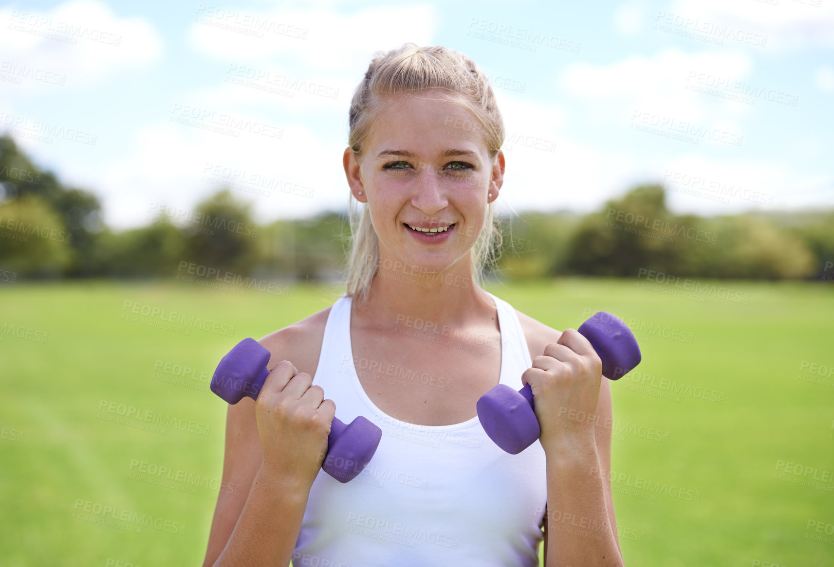 Buy stock photo Woman, portrait and dumbbells outdoor for workout with smile for exercise, training or fitness on sports field. Athlete, person and happy for physical activity or healthy body on grass with equipment