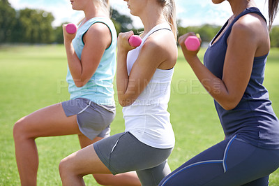 Buy stock photo Shot of a group of young women working out with dumbbells