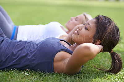 Buy stock photo Woman, sit ups and workout on field for fitness or outdoor exercise together in nature. Young active female person or people lying on green grass for core strength, abs or outside training class