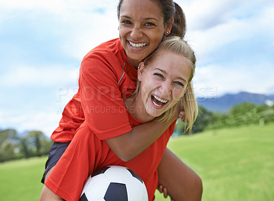 Buy stock photo Happy woman, friends and piggyback with soccer ball on green grass for winning, achievement or sports in nature. Portrait of female person or football player smile for hug, match or game on field