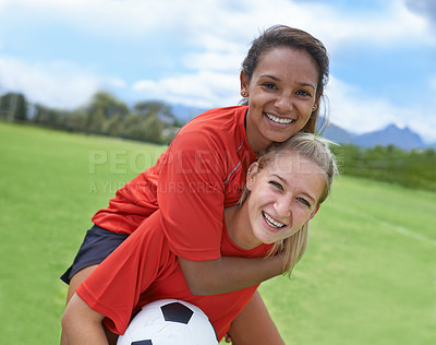Buy stock photo Shot of a female soccer player carrying her teammate on her back