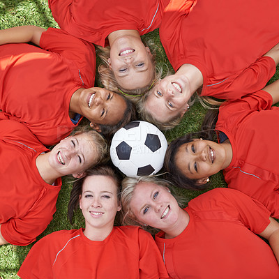 Buy stock photo Happy woman, soccer ball and face of team above for unity, collaboration or synergy lying on green grass. Top view or portrait of female person, group or football players smile on outdoor field