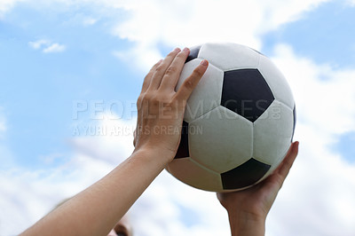 Buy stock photo Hands, blue sky and closeup of ball for soccer exercise, game or training in outdoor field. Sports, fitness and zoom of person holding equipment for football match or workout in park or pitch.