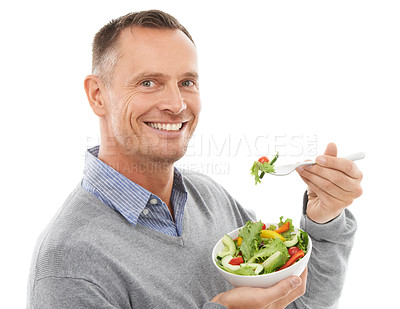 Buy stock photo Portrait, food and diet with a man in studio isolated on a white background eating vegetables for health. Green, nutrition and health with a mature male indoor to eat an organic salad for wellness