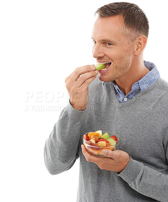 Buy stock photo Mature man eating fruits isolated on a white background for healthy green lunch, diet choice or nutritionist breakfast. Professional vegan person or model with fruits salad, food or apple in studio