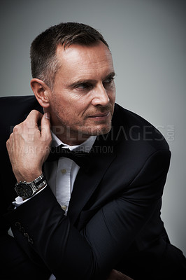 Buy stock photo Success, handsome and mature man in tuxedo and serious and isolated on grey background in studio. Luxury, glamour and wealth with cool celebrity actor style, elegant and sexy date for valentines day.