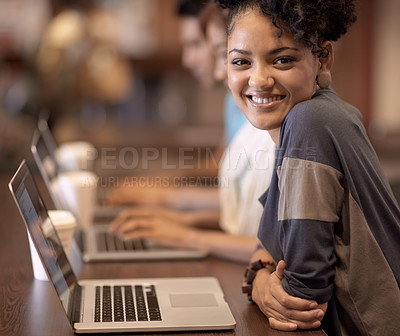 Buy stock photo A group of students using a laptop to complete a group assignment
