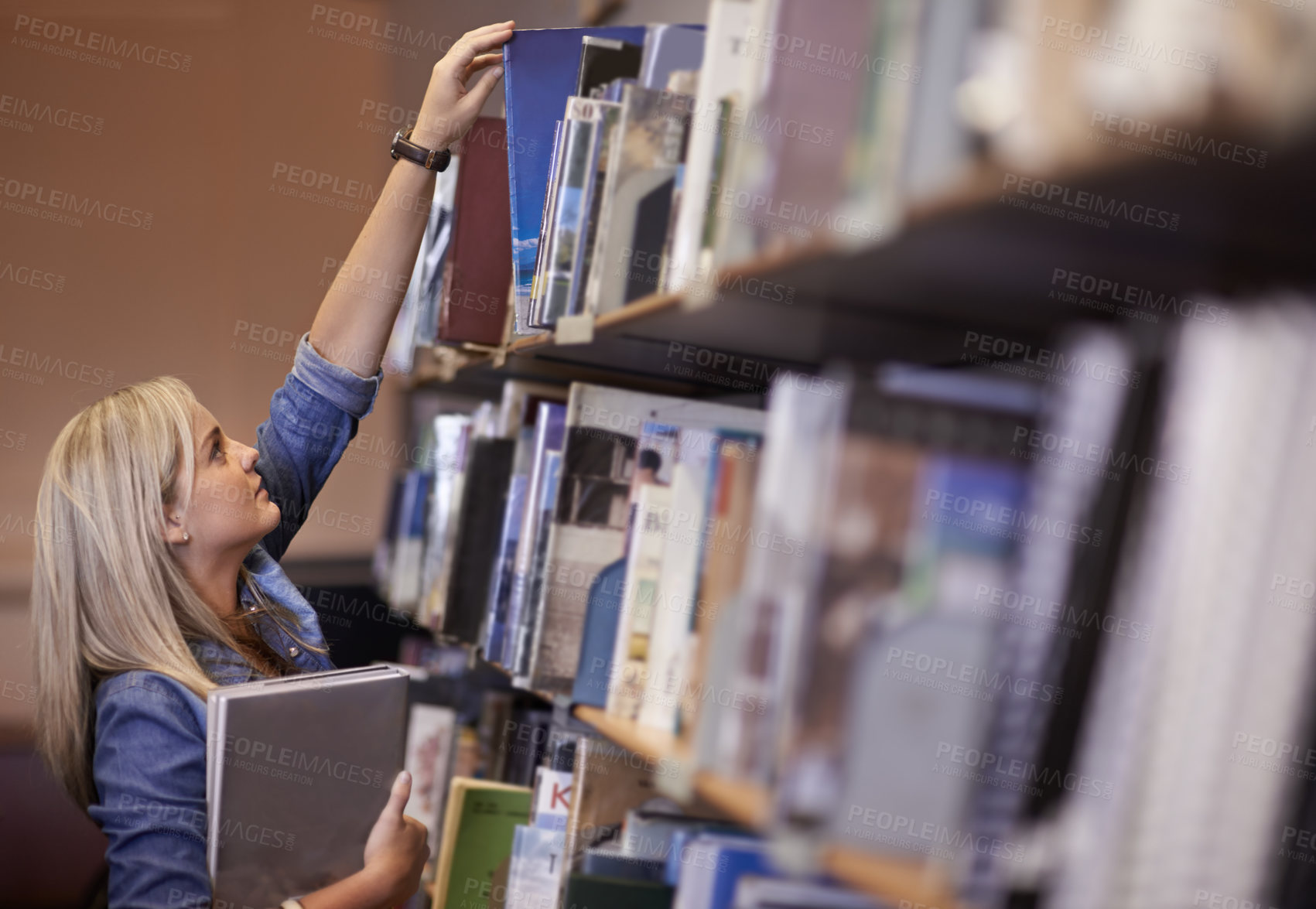 Buy stock photo Shot of a young college student in a library