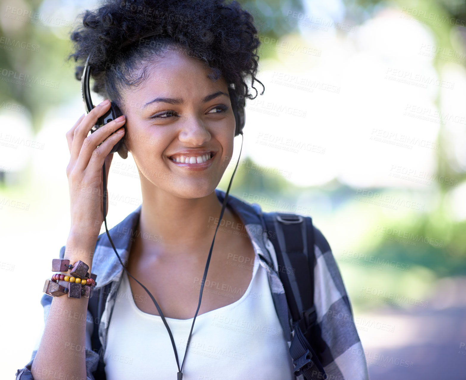 Buy stock photo A young woman with headphones around her neck