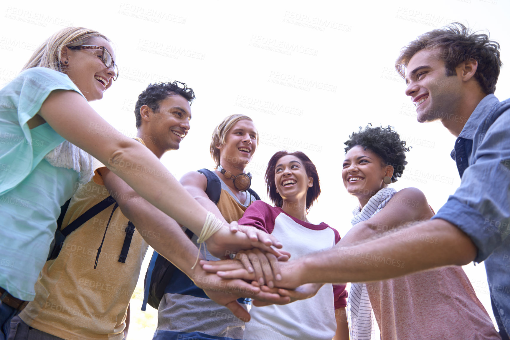 Buy stock photo Shot of a group of students putting their hands in a huddle