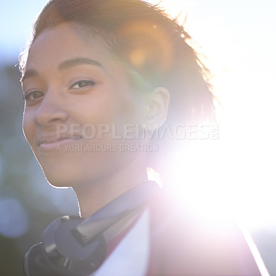 Buy stock photo A pretty woman looking at the camera with headphones around her neck