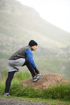 Buy stock photo Nature, man and tie laces for run, fitness or morning workout with stretch in Cape Town. Male runner, thinking and preparing for warm up for health, exercise or athletics competition on mountain