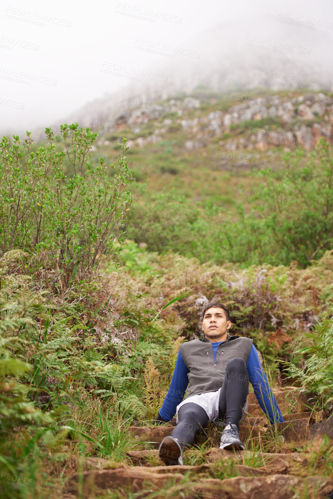 Buy stock photo Tired, runner and man on break in nature training, cardio exercise and endurance workout for wellness. Sports, fitness fatigue or healthy athlete resting in forest or uphill mountain trail outdoors