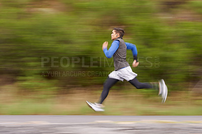 Buy stock photo Motion blurred image of a young man running along the road