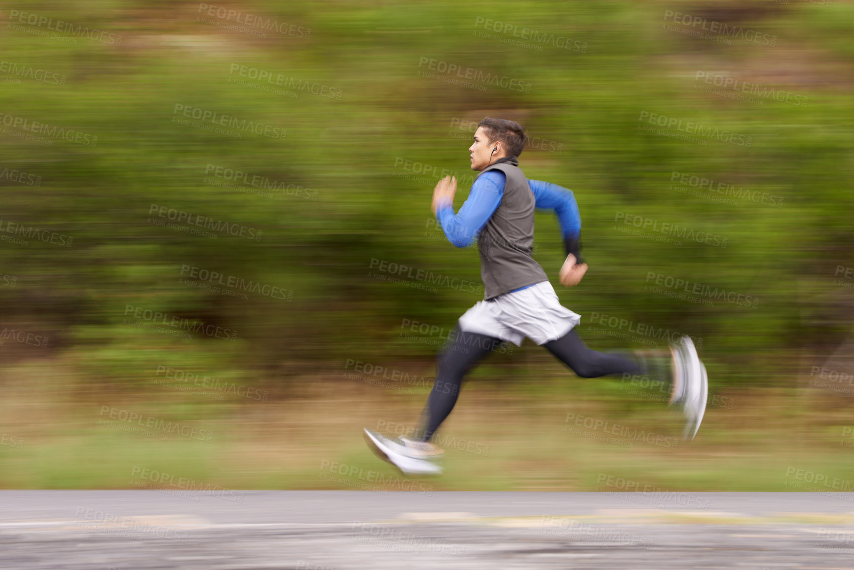 Buy stock photo Motion blurred image of a young man running along the road