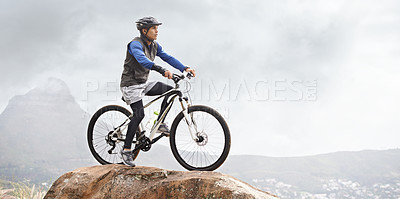 Buy stock photo A young man on a mountain bike with a gorgeous view in the background