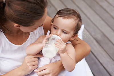 Buy stock photo Baby, mother and drinking formula for nutrition, food and relaxing together on porch at home. Mommy, toddler and bottle for health or child development in outdoors, feeding and milk for wellness
