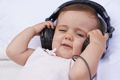 Buy stock photo Baby, headphones and listening to music for fun, streaming radio and podcast on bed at home. Child, relax and hearing sound for child development or learning, toddler and calming playlist for audio
