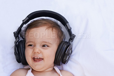Buy stock photo Baby, headphones and listening to song for fun, above and face on bed at home. Child, happiness and hearing audio for child development or learning, toddler and calming playlist for peace and calm