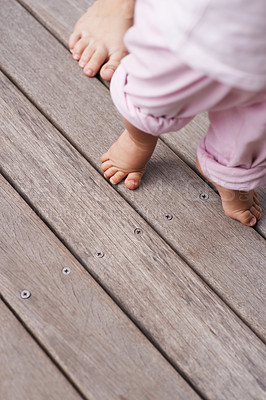 Buy stock photo Cropped closeup image of a mother helping her baby to take her first steps