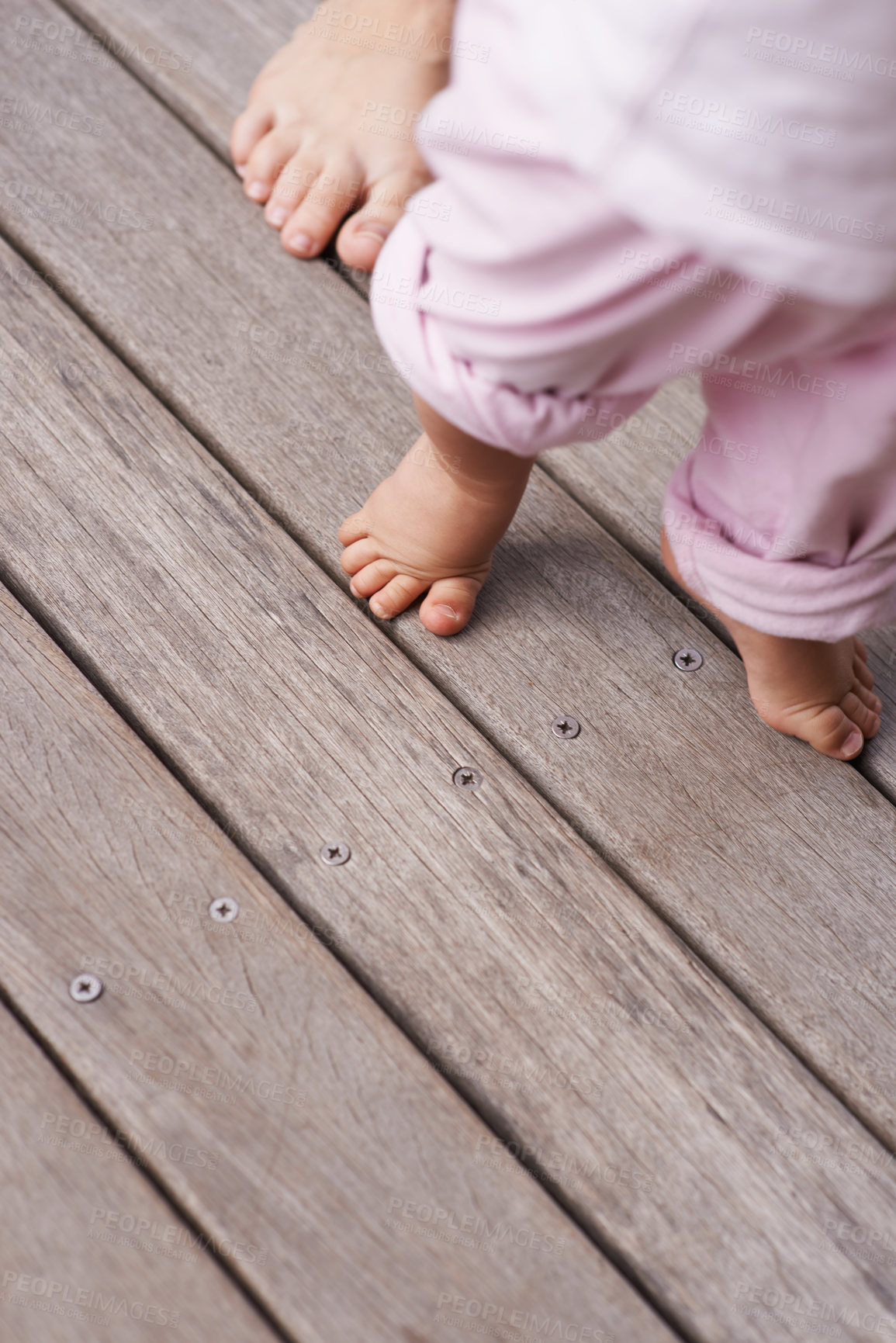 Buy stock photo Cropped closeup image of a mother helping her baby to take her first steps