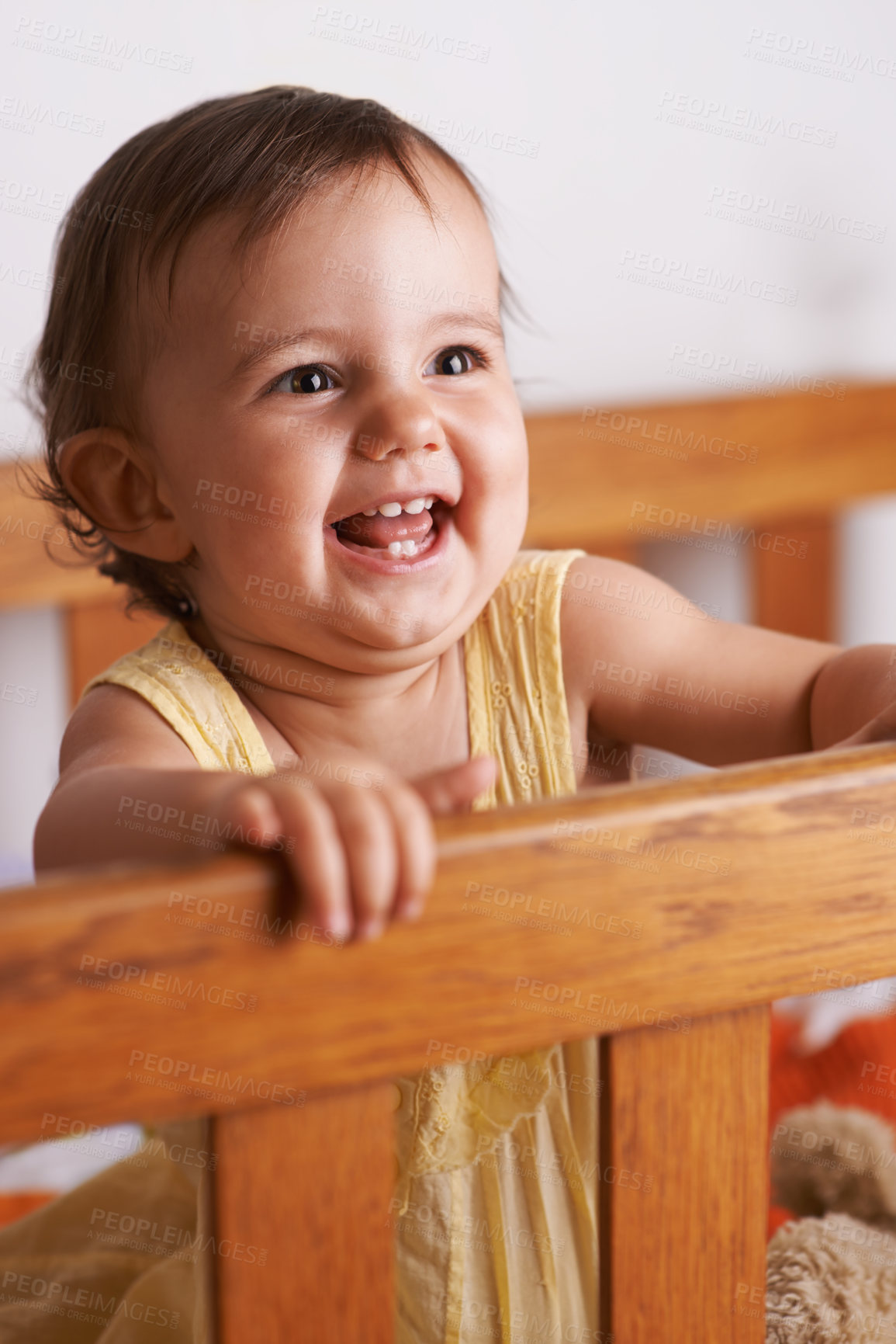 Buy stock photo Excited baby in crib, playing with smile and fun in home, child development and care in home. Toddler girl in cot with playful face, energy and happiness in cute kids bedroom, nursery or apartment.