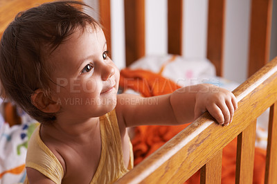 Buy stock photo Baby girl in crib, playing with smile and fun in home, child development and care in home. Toddler in cot with playful face, energy and happiness in cute kids bedroom, nursery or apartment at bedtime