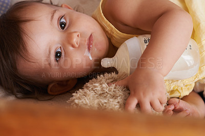 Buy stock photo A little girl lying in her cot with her bottle