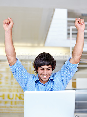 Buy stock photo Shot of an ecstatic young businessman celebrating in front of his laptop