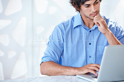 Buy stock photo Shot of a young business professional at work on his laptop