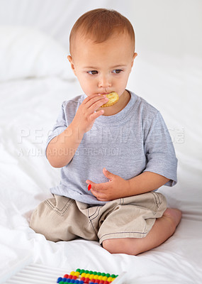 Buy stock photo Cute, bed and baby eating biscuit for yummy snack playing with abacus for education. Child development, sweet and hungry young boy kid, infant or toddler enjoying a cracker in bedroom at home.